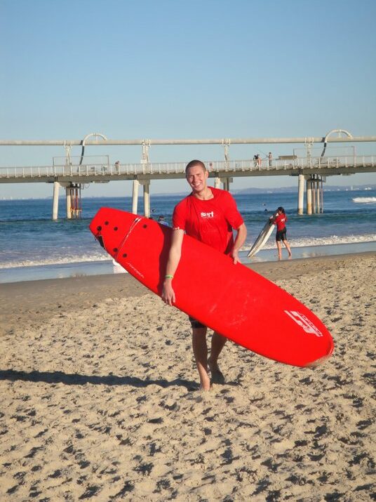 Tad on an Australian beach with a surfboard